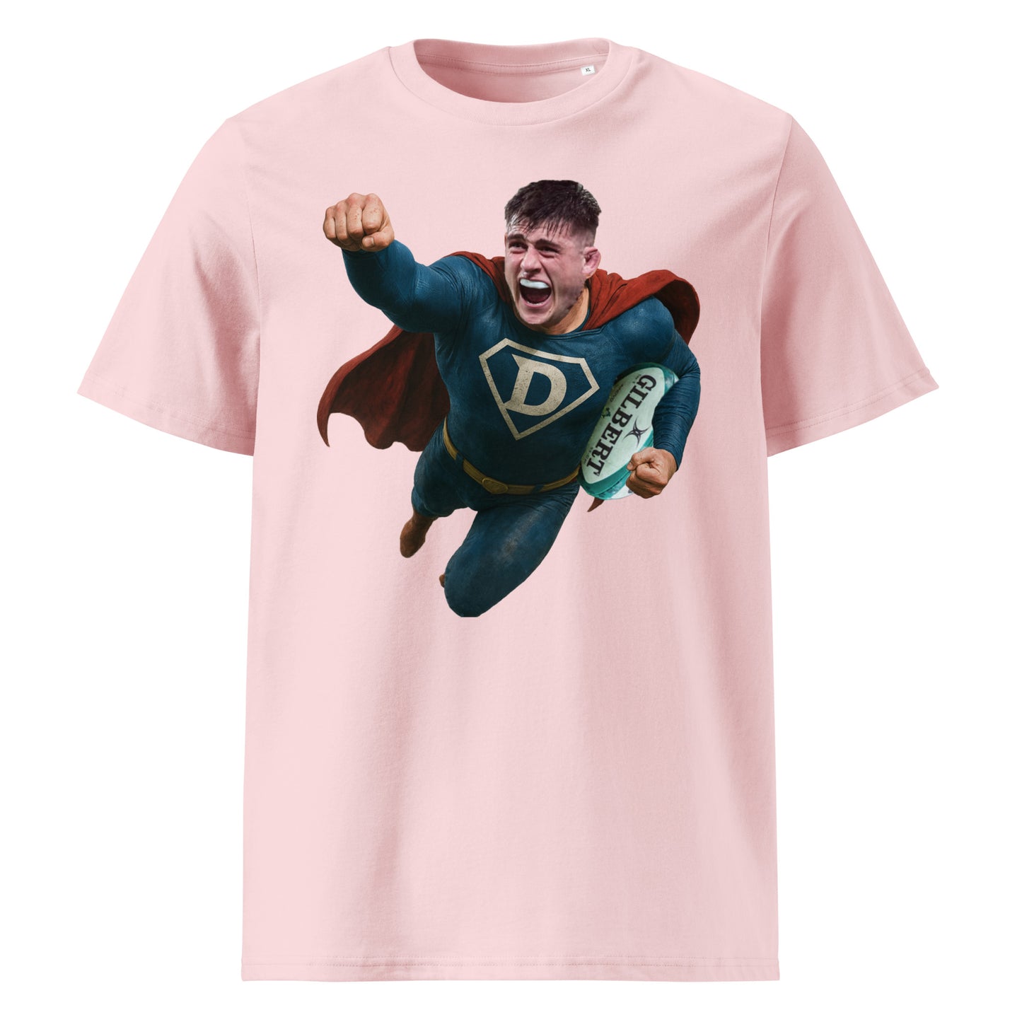 Pink t-shirt with a vibrant superhero graphic of Dan Sheehan soaring through the air, rugby ball in hand. The red cape and blue suit pop against the pink background — a fun, bold choice for fans of flair and forward dominance.