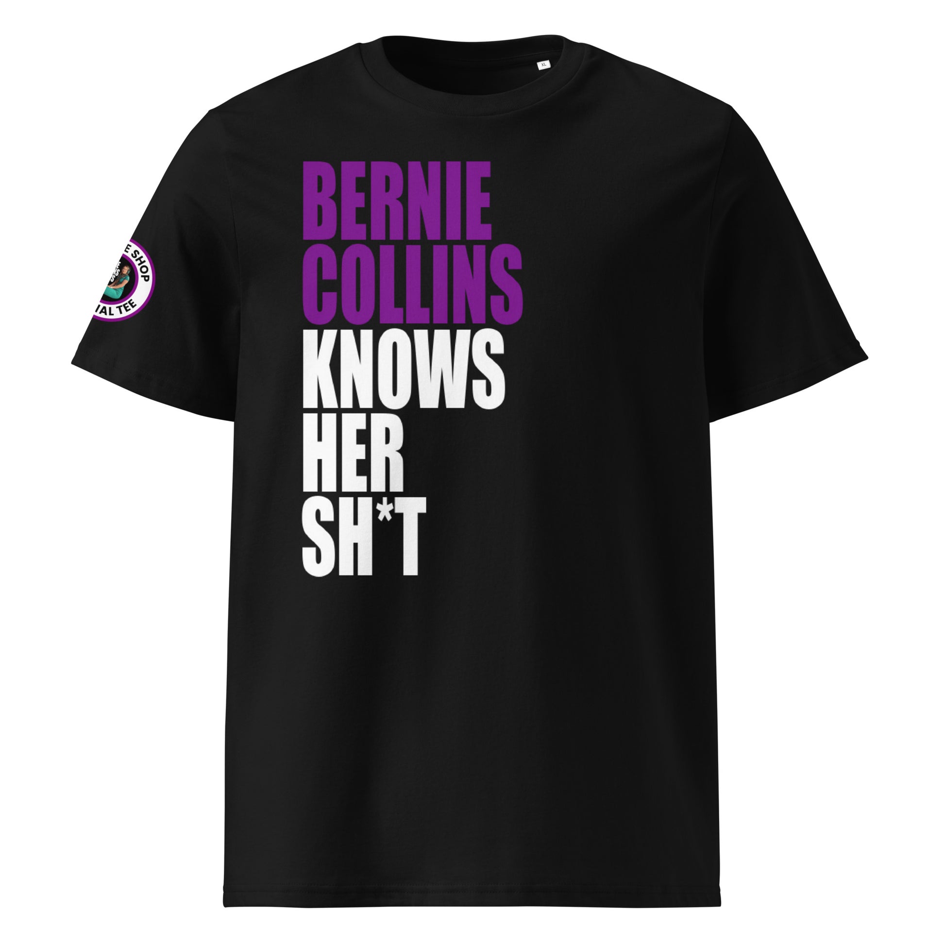 Front view of black unisex t-shirt with bold slogan: “BERNIE COLLINS” in purple (F1 purple sector) and “KNOWS HER SH*T” in white, stacked vertically. DTF print, perfect for F1 and Sky Sports fans.