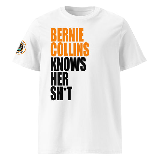 Front view of white unisex t-shirt with bold slogan: “BERNIE COLLINS” in McLaren papaya orange and “KNOWS HER SH*T” in black, stacked vertically. DTF print, perfect for McLaren and F1 fans.