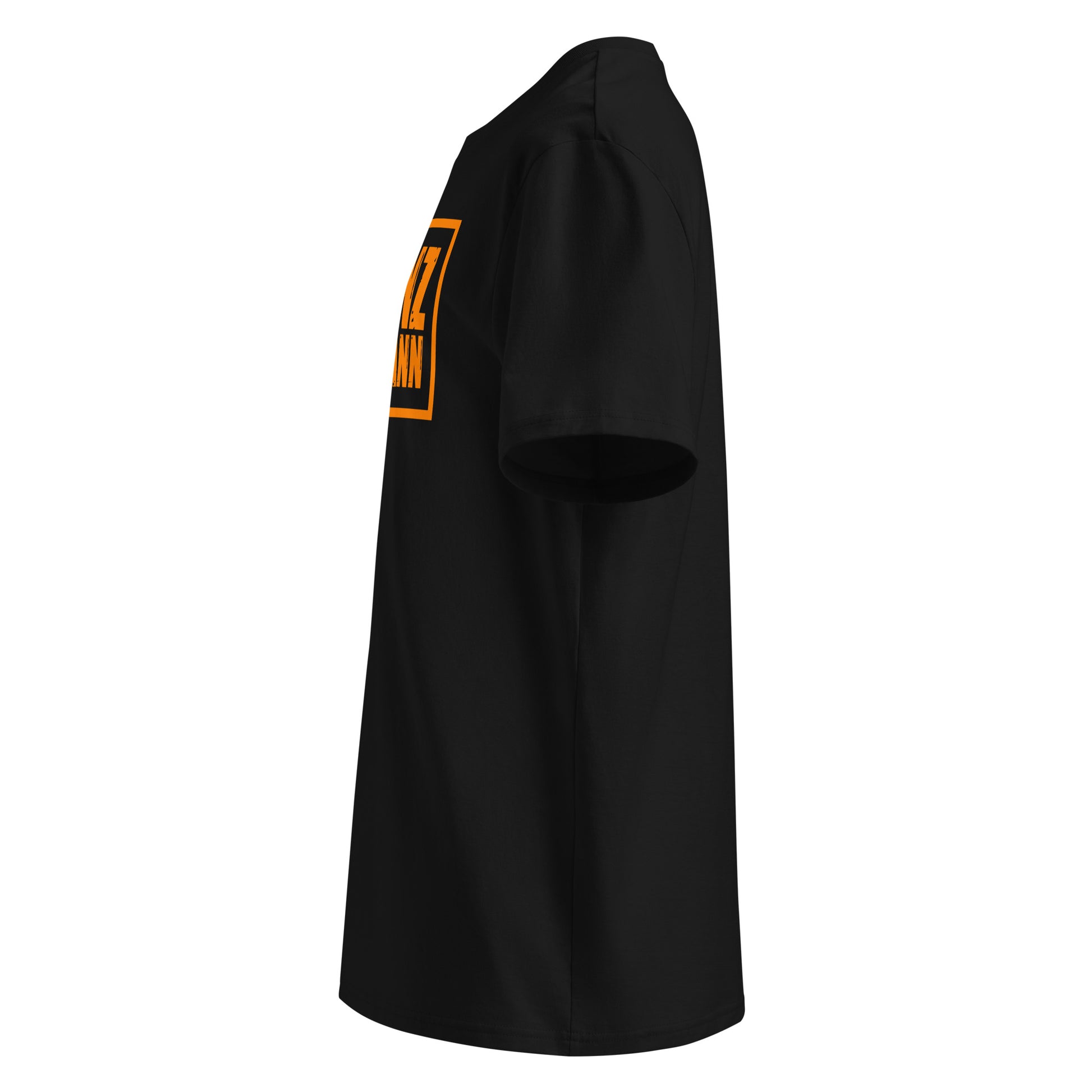 Left side view of black unisex t-shirt, plain sleeve, visible side of distressed orange Franz Hermann box logo. Minimalist, motorsport style.