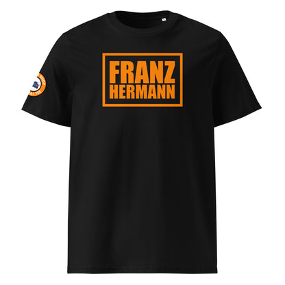Front view of black unisex t-shirt with bold orange “Franz Hermann” box logo printed on the chest. DTF print, Dutch-inspired for Max Verstappen and F1 fans. Clean, professional motorsport style.