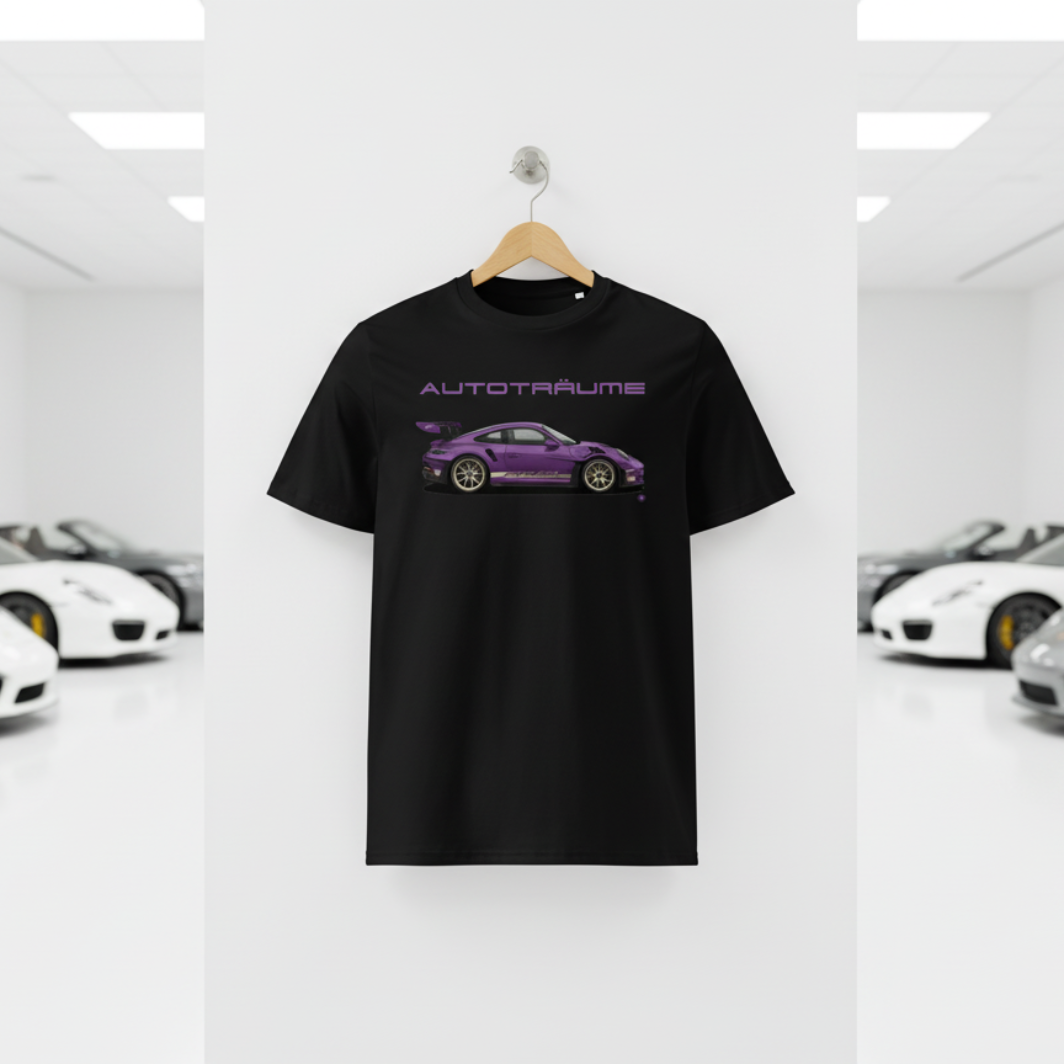Black AUTOTRÄUME GT3 T‑shirt with a purple Porsche‑style car illustration hanging on a premium wooden hanger and silver wall peg against a central white wall in a bright sports car gallery, with a glossy white floor and blurred white and silver sports cars running down both sides.