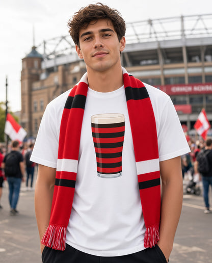 Male model wearing a white Blackheath rugby Mega Pint t-shirt with a red and black striped pint glass graphic and a red scarf, photographed in a London match day crowd for Blackheath and England supporters