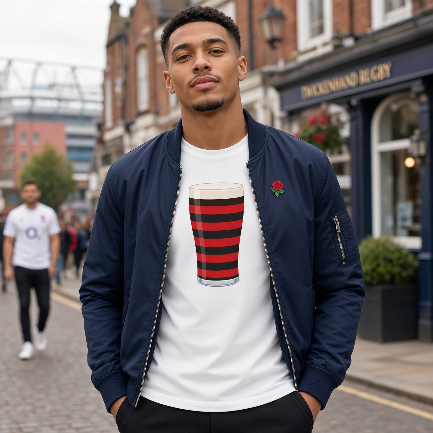 Male model wearing a white Blackheath rugby Mega Pint t-shirt with a red and black striped pint glass graphic, styled with a jacket for South East London match days and England rugby supporters