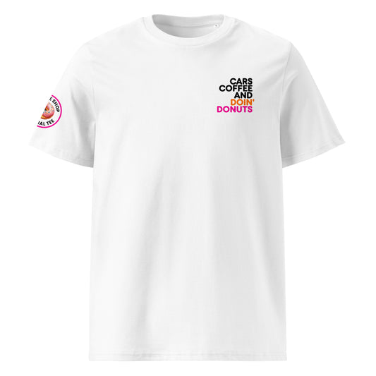 White unisex t-shirt with small “Cars Coffee and Doin’ Donuts” slogan printed on the right chest in black, orange, and pink. Features The Tee Shop donut logo patch on the right sleeve. Minimalist car meet tee, DTF printed.