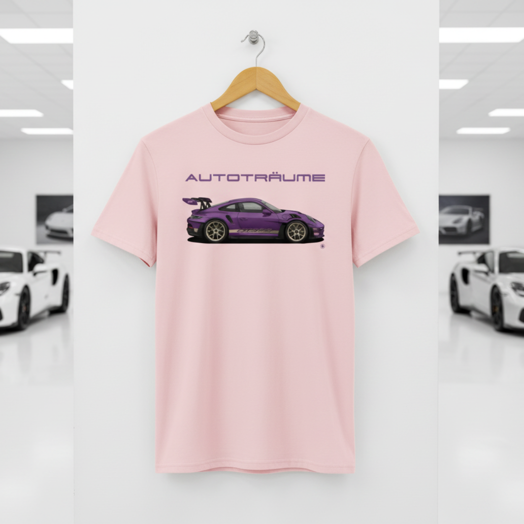 Cotton pink AUTOTRÄUME GT3 T‑shirt with a purple Porsche‑style car illustration hanging on a premium wooden hanger and silver wall peg against a central white wall in a bright sports car gallery, with a glossy white floor and blurred white and silver sports cars running down both sides.