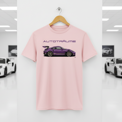 Cotton pink AUTOTRÄUME GT3 T‑shirt with a purple Porsche‑style car illustration hanging on a premium wooden hanger and silver wall peg against a central white wall in a bright sports car gallery, with a glossy white floor and blurred white and silver sports cars running down both sides.