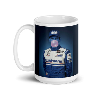 White ceramic 15oz mug featuring a pop-art style portrait of Damon Hill in a blue racing suit and cap, blue-tinted face, and blowing a bubblegum bubble, set against a blue background.