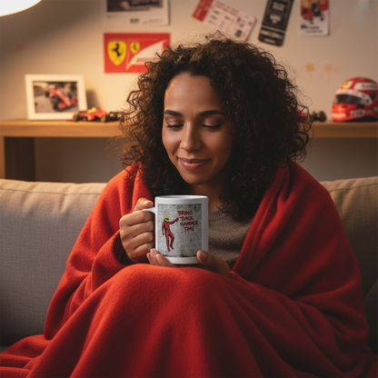A female Lewis Hamilton and Ferrari fan wrapped in a blanket, sipping from the Scuderia Series: Bring Back Hammer Time Graffiti Mug, surrounded by Ferrari memorabilia.