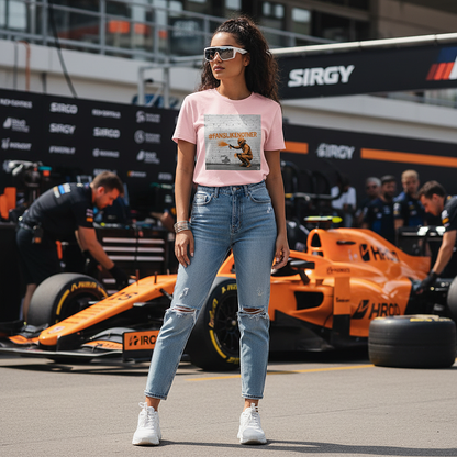 Female model wearing the cotton pink organic cotton PAPAYA Fans Like No Other Graffiti Art f1 T-Shirt with #FANSLIKENOOTHER design, standing with arms relaxed by her sides in a full-frame motorsport paddock environment, tee clean and design fully visible.