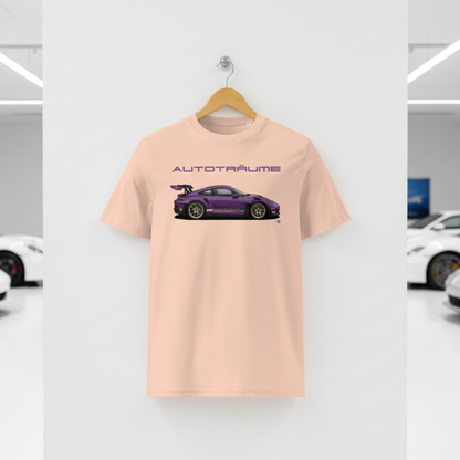 Light peach Fraîche Pêche AUTOTRÄUME GT3 T‑shirt with a purple Porsche‑style car illustration hanging on a premium wooden hanger and silver wall peg against a central white wall in a bright sports car gallery, with a glossy white floor and blurred white and silver sports cars running down both sides.
