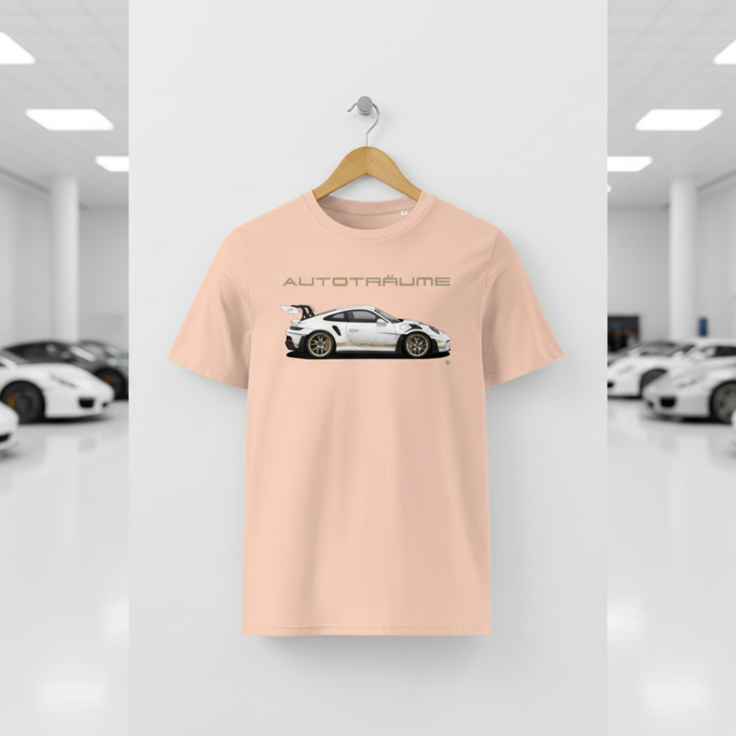 Pale peach Fraiche Peche unisex organic cotton AUTOTRÄUME GT3 RS T-shirt featuring a large, centred white Porsche-style GT3 RS car graphic with gold details hanging on a premium wooden hanger with a silver wall peg against a clean white wall panel in a bright modern sports car gallery with glossy floors and blurred white and silver sports cars on both sides.
