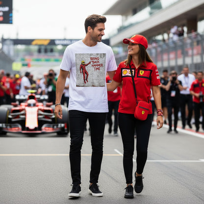 Two people walking on a race track with a race car in the background