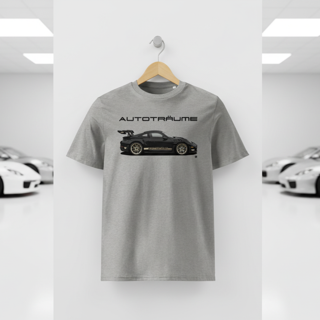 Heather grey AUTOTRÄUME GT3 T‑shirt with a black Porsche‑style car and gold highlights illustration hanging on a premium wooden hanger and silver wall peg against a central white wall in a bright sports car gallery, with a glossy white floor and blurred white and silver sports cars running down both sides.
