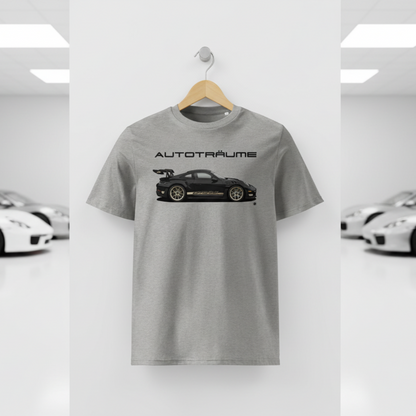 Heather grey AUTOTRÄUME GT3 T‑shirt with a black Porsche‑style car and gold highlights illustration hanging on a premium wooden hanger and silver wall peg against a central white wall in a bright sports car gallery, with a glossy white floor and blurred white and silver sports cars running down both sides.
