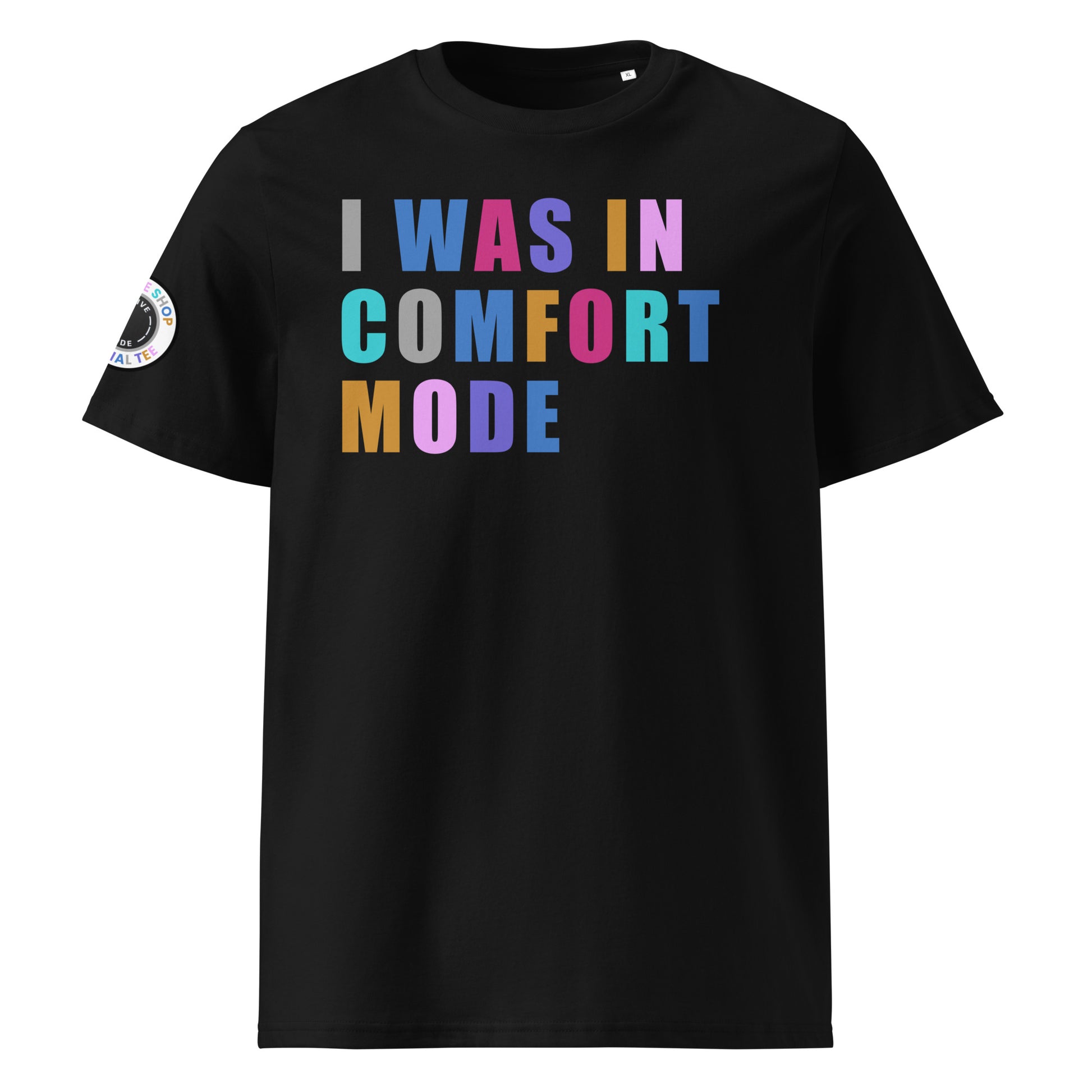 Front view of black unisex t-shirt with “I WAS IN COMFORT MODE” slogan in multi-colour harlequin print across the chest. DTF print, playful car meet and petrolhead style.
