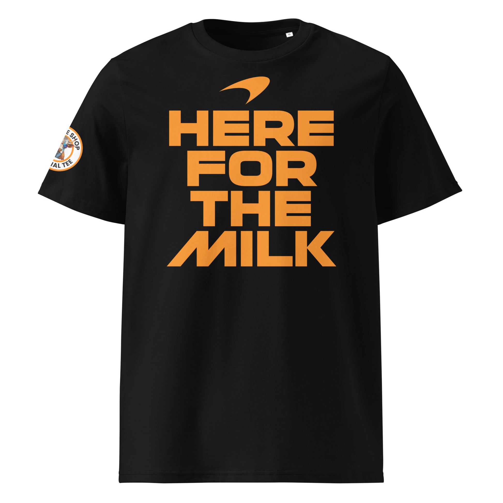 Front view of the black Indy 500 “Here for the Milk” T-Shirt featuring bold papaya orange text and a McLaren-inspired swoosh logo.