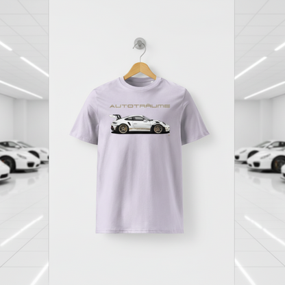 Lavender unisex organic cotton AUTOTRÄUME GT3 RS T-shirt featuring a large, centred white Porsche-style GT3 RS car graphic with gold details hanging on a premium wooden hanger with a silver wall peg against a clean white wall panel in a bright modern sports car gallery with glossy floors and blurred white and silver sports cars on both sides.