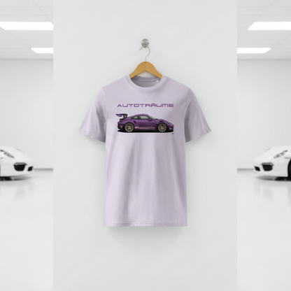 Pale lavender AUTOTRÄUME GT3 T‑shirt with a purple Porsche‑style car illustration hanging on a premium wooden hanger and silver wall peg against a central white wall in a bright sports car gallery, with a glossy white floor and blurred white and silver sports cars running down both sides.