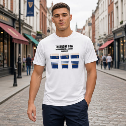 Male model wearing a white Leinster rugby t-shirt reading “The Front Row - Downing Pints & Scrums Since 1879” with three blue striped pint graphics featuring a harp crest, photographed outdoors for Leinster match day supporters