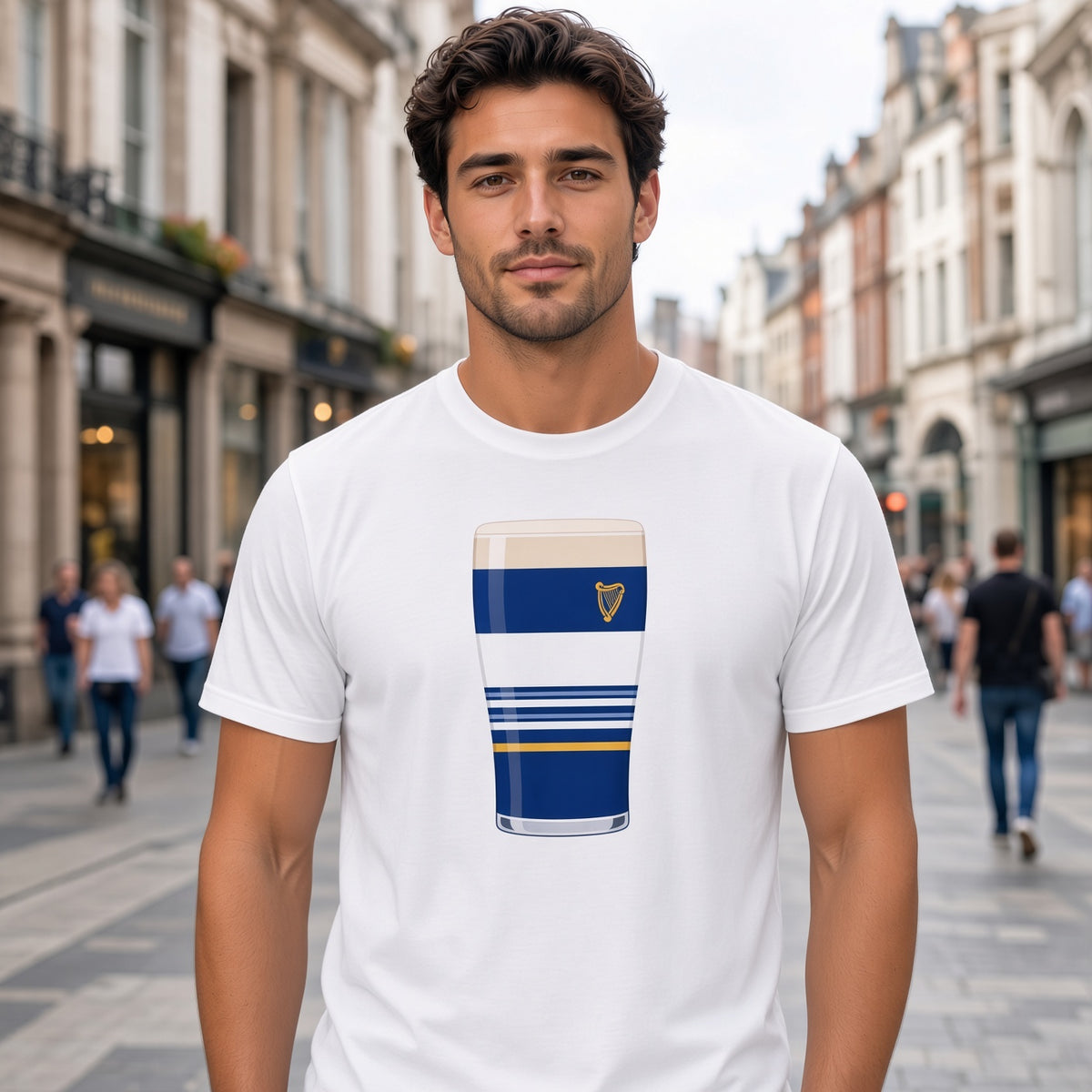 Male model wearing a white Leinster Striped Mega Pint rugby t-shirt featuring a blue pint glass graphic with white stripes, gold accent line and harp crest, photographed outdoors for Leinster supporters
