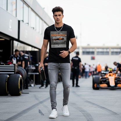 Male model wearing the black organic cotton Papaya Rules 2.0 graffiti art F1 t-shirt without a jacket, styled casually in a motorsport paddock environment with motorsport props.