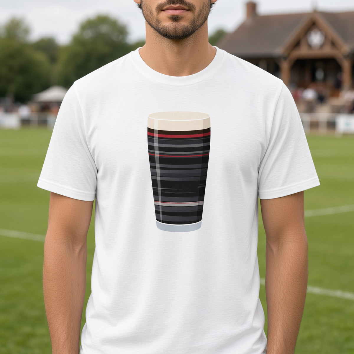 Male rugby fan wearing white Saracens retro change mega pint rugby t-shirt near rugby pitch