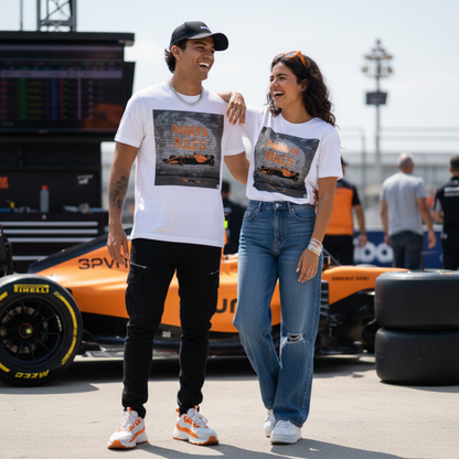 Male and female models together wearing white organic cotton Papaya Rules graffiti art t-shirts in a motorsport paddock, styled fashionably with motorsport props and a casual vibe.