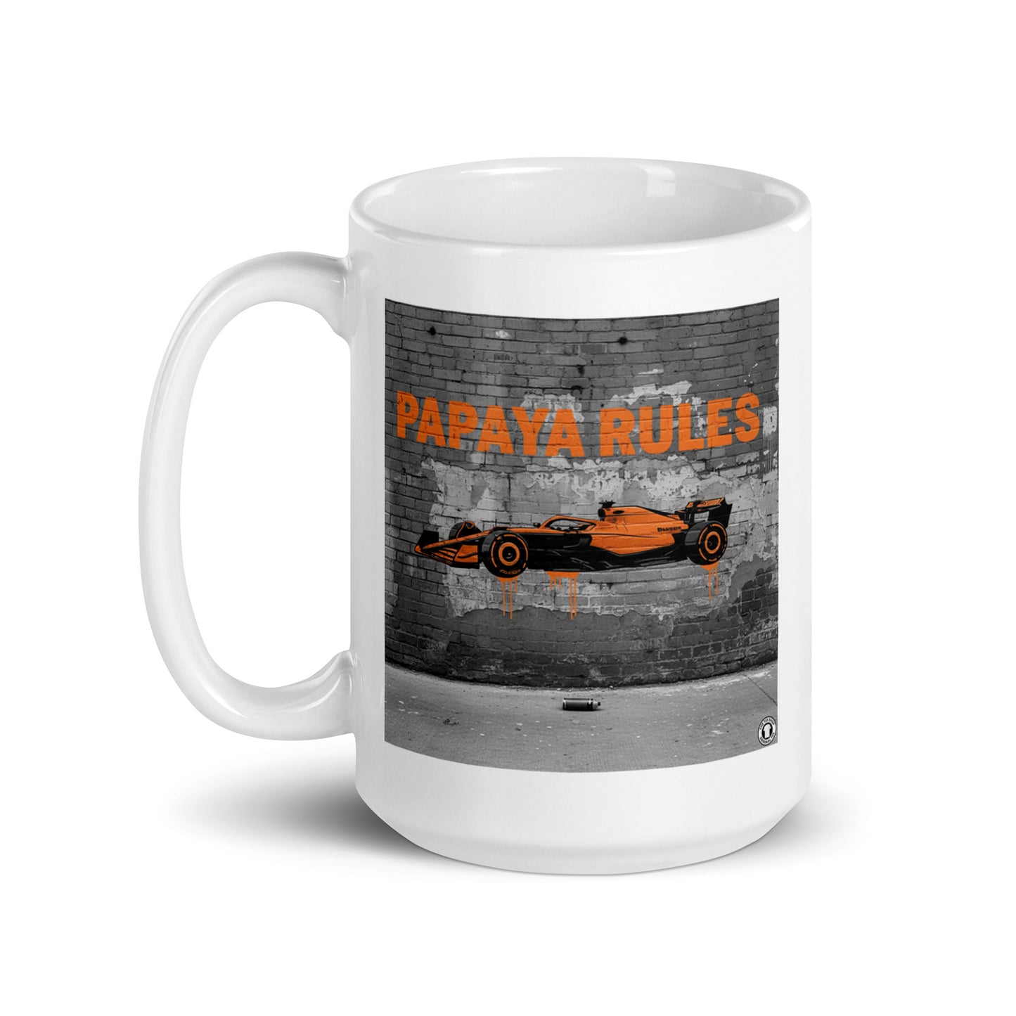 White ceramic 15oz mug featuring a street art illustration of a papaya orange McLaren F1 car and “PAPAYA RULES” graffiti on a distressed brick wall.
