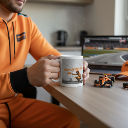 Male F1 fan in papaya loungewear, drinking from the Papaya Fans Like No Other Mug at home, with McLaren memorabilia in the background.