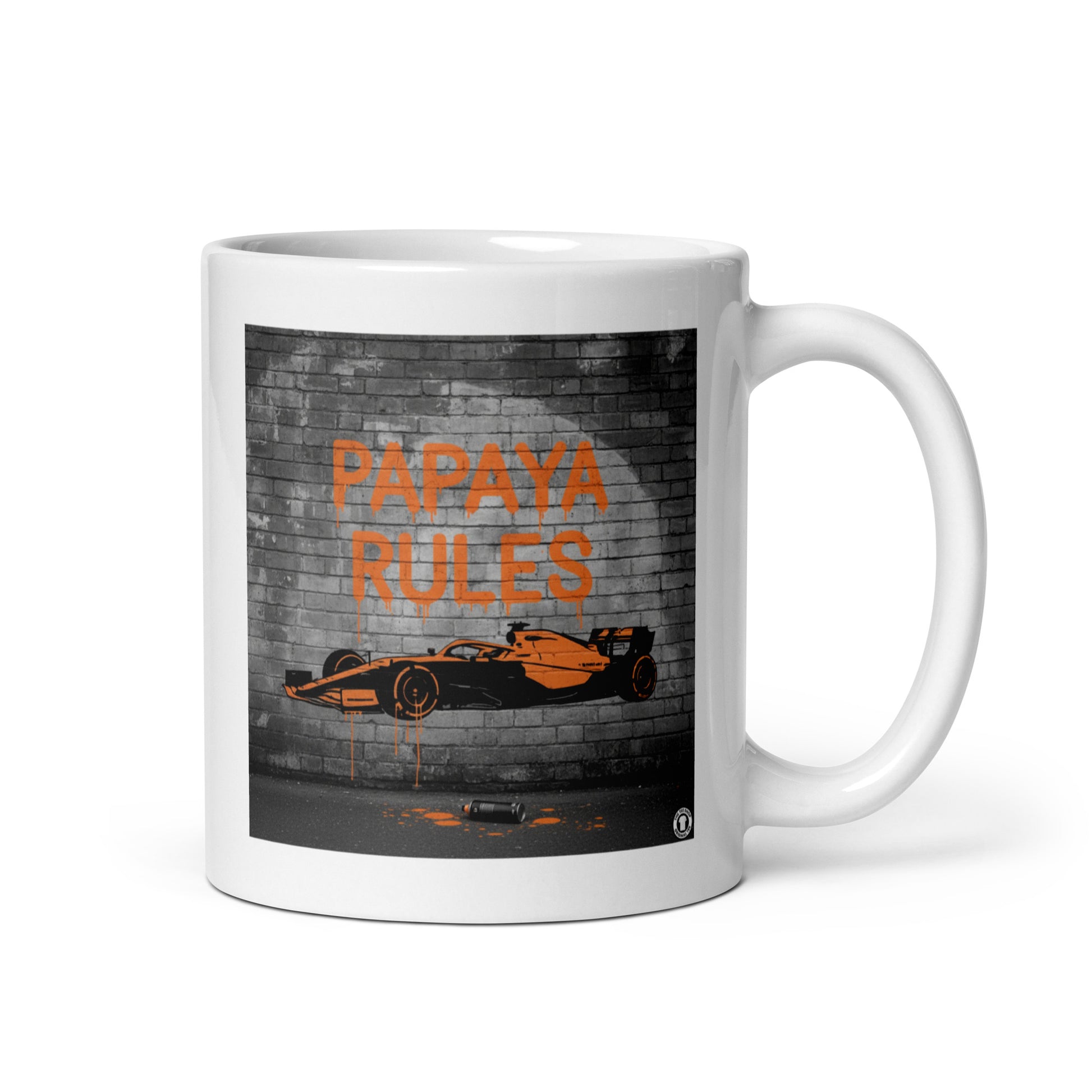 White ceramic 11oz mug featuring a street art illustration of a papaya orange McLaren F1 car and “PAPAYA RULES” graffiti on a dark brick wall.