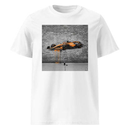 White unisex t-shirt featuring a graffiti-style mural of a McLaren F1 car in papaya orange with paint drips, part of TheTeeShop’s Papaya Series in the Paddock Collection.