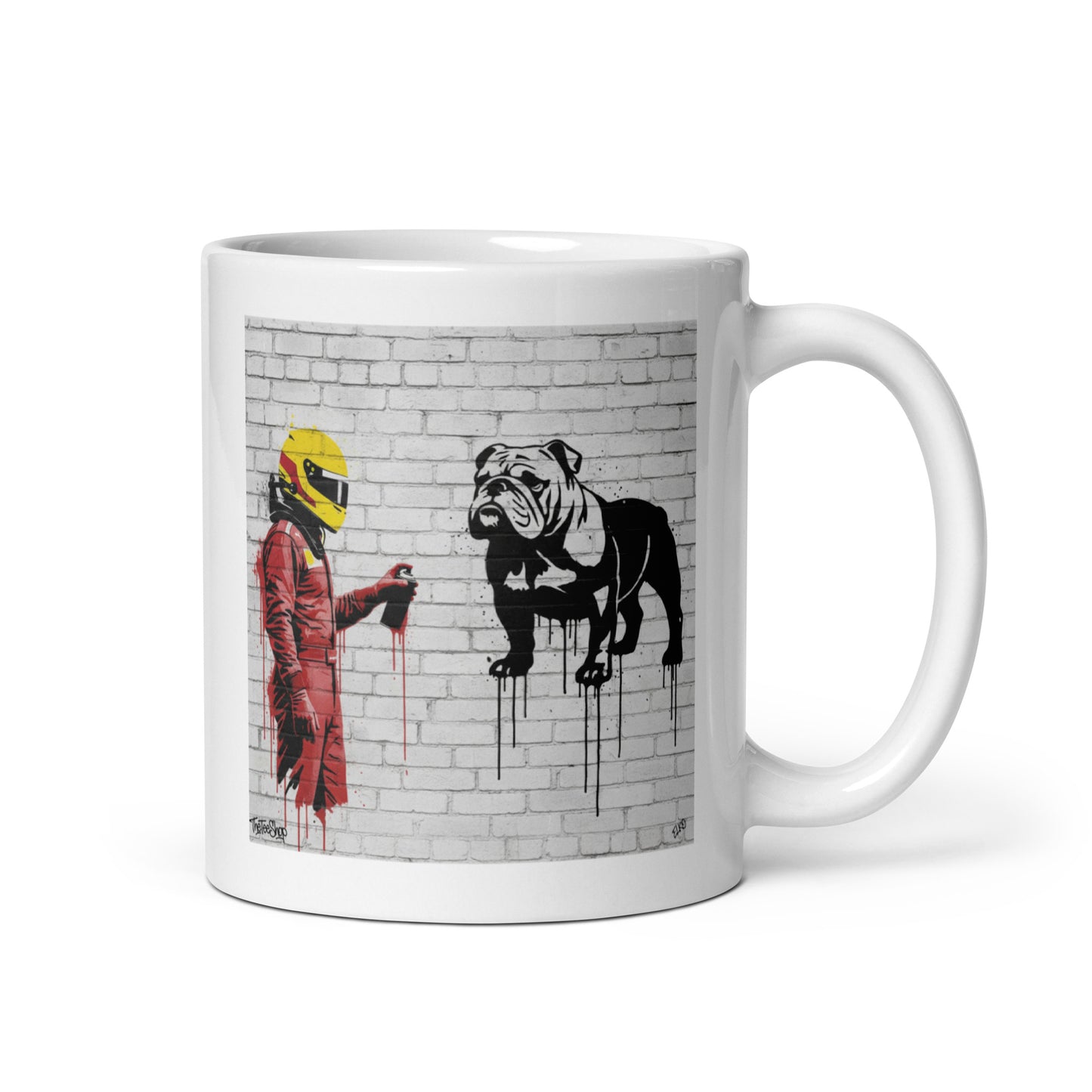White ceramic 11oz mug featuring a street art illustration of a racing driver in red overalls and a yellow helmet spray-painting a black and white bulldog on a white brick wall, inspired by a man and his dog.