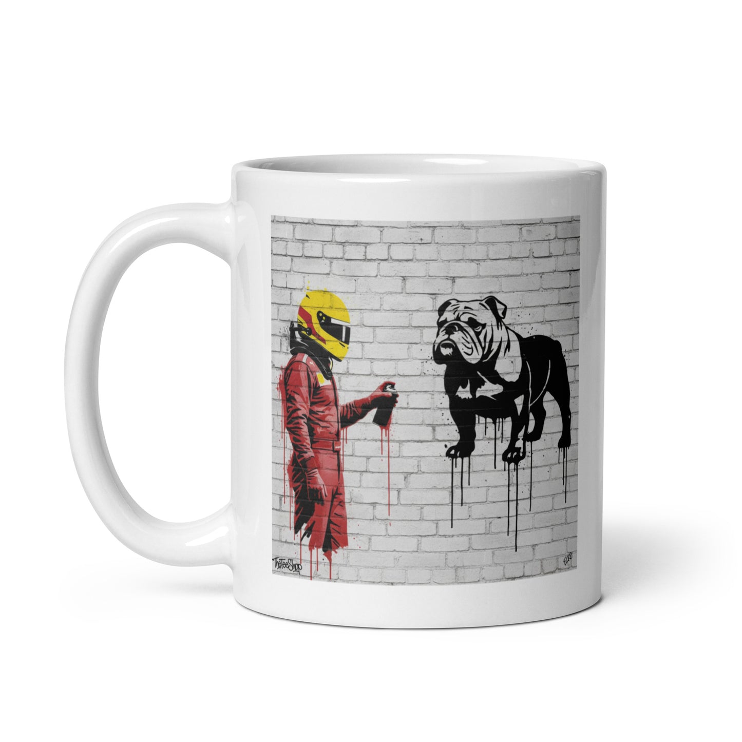 White ceramic 11oz mug featuring a street art illustration of a racing driver in red overalls and a yellow helmet spray-painting a black and white bulldog on a white brick wall.