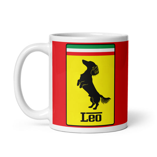 White ceramic 11oz mug with a bold red background featuring a Ferrari-style yellow shield, the Italian tricolor, and a black silhouette of a dachshund rearing up like a prancing horse, with the text “Leo”—inspired by Charles Leclerc’s famous F1 dog.