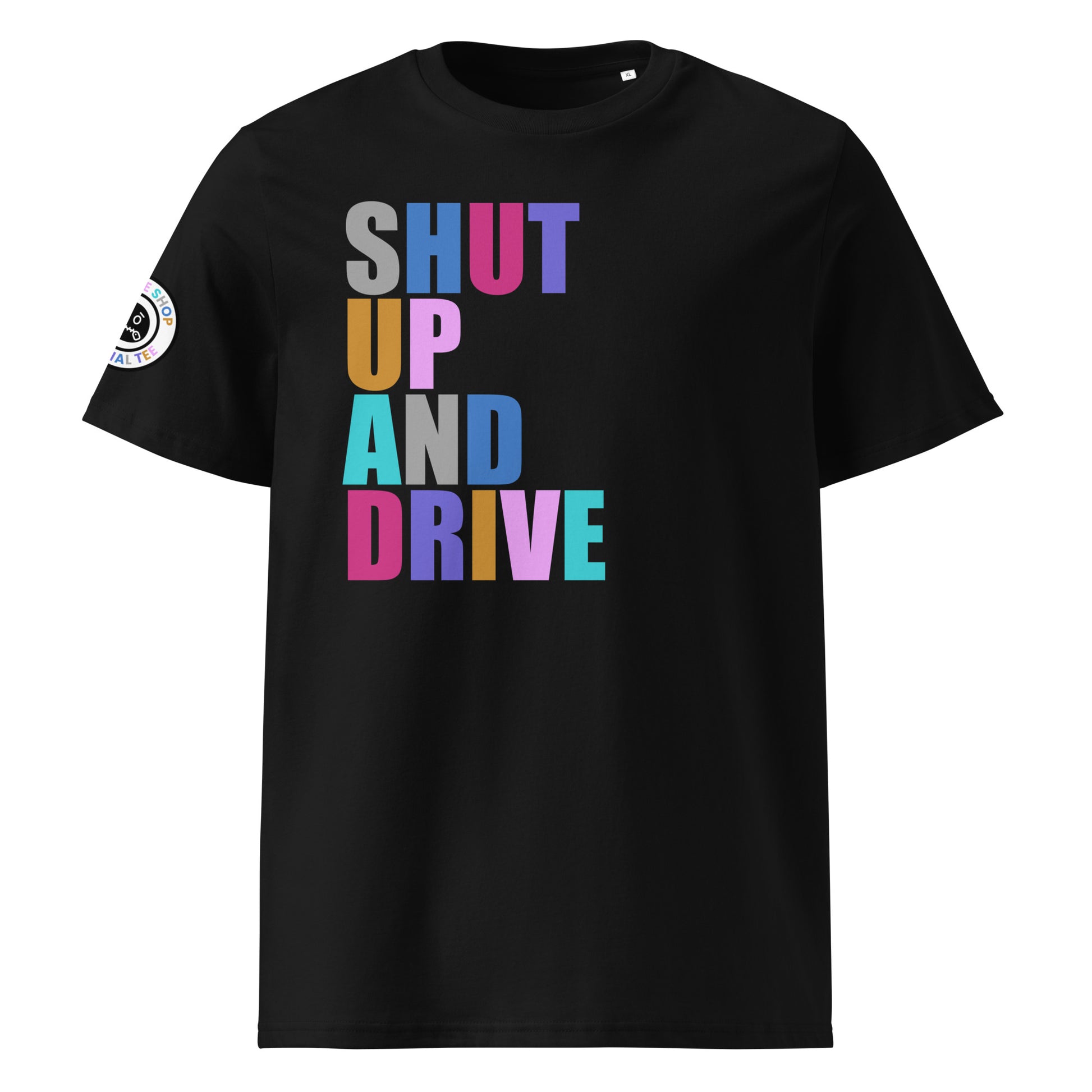 Front view of black unisex t-shirt with “SHUT UP AND DRIVE” slogan in multi-colour harlequin print across the chest. DTF print, perfect for car meet fans and driving enthusiasts.