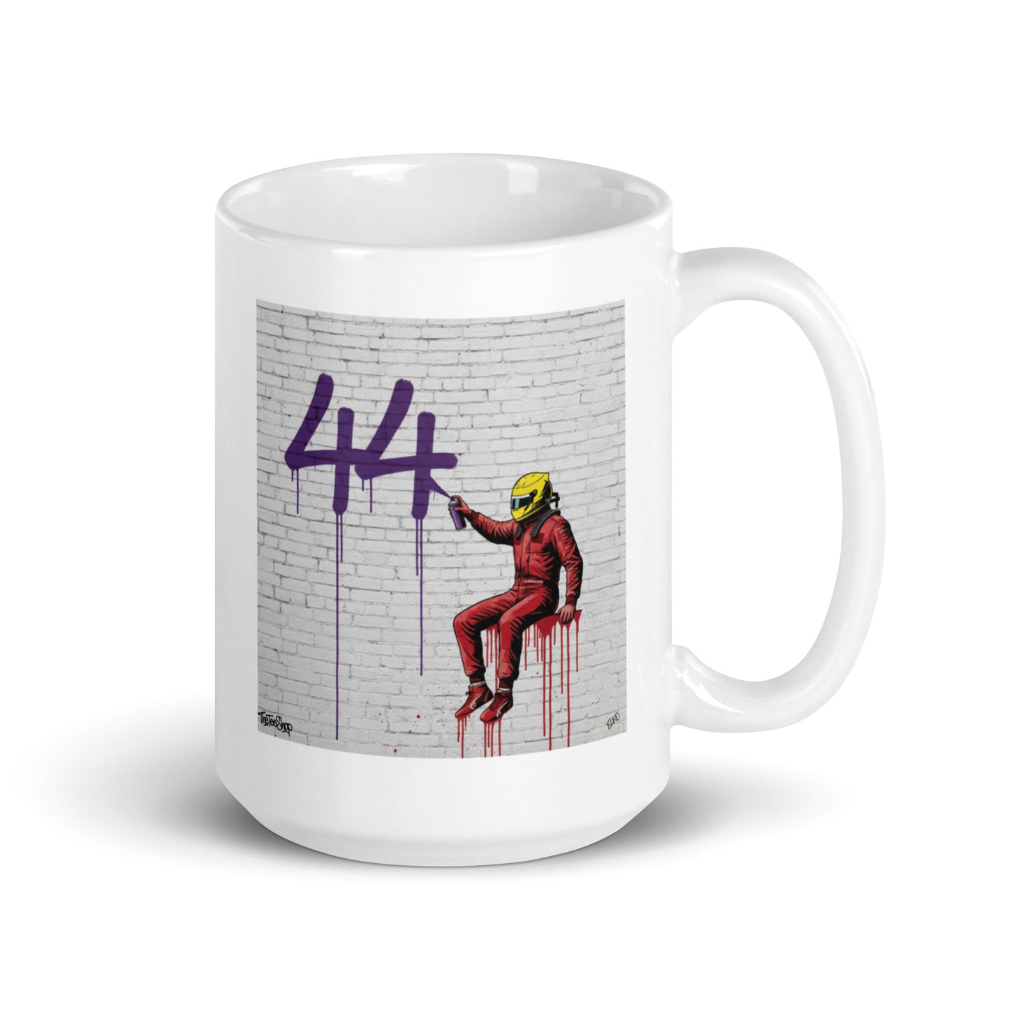 White ceramic 15 oz mug featuring a street art illustration of a racing driver in Ferrari red overalls and a yellow helmet spray-painting a large purple 44 on a white brick wall, inspired by Lewis Hamilton and Ferrari.