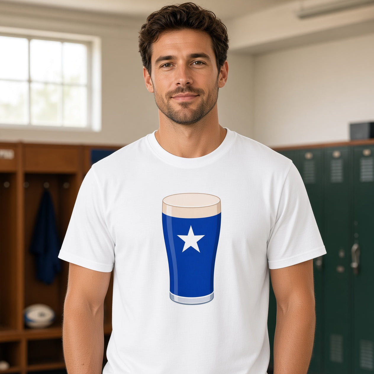 Male model wearing a white St Mary’s College Mega Pint rugby t-shirt with a blue pint glass and white star graphic, photographed in a rugby changing room setting for match day supporters