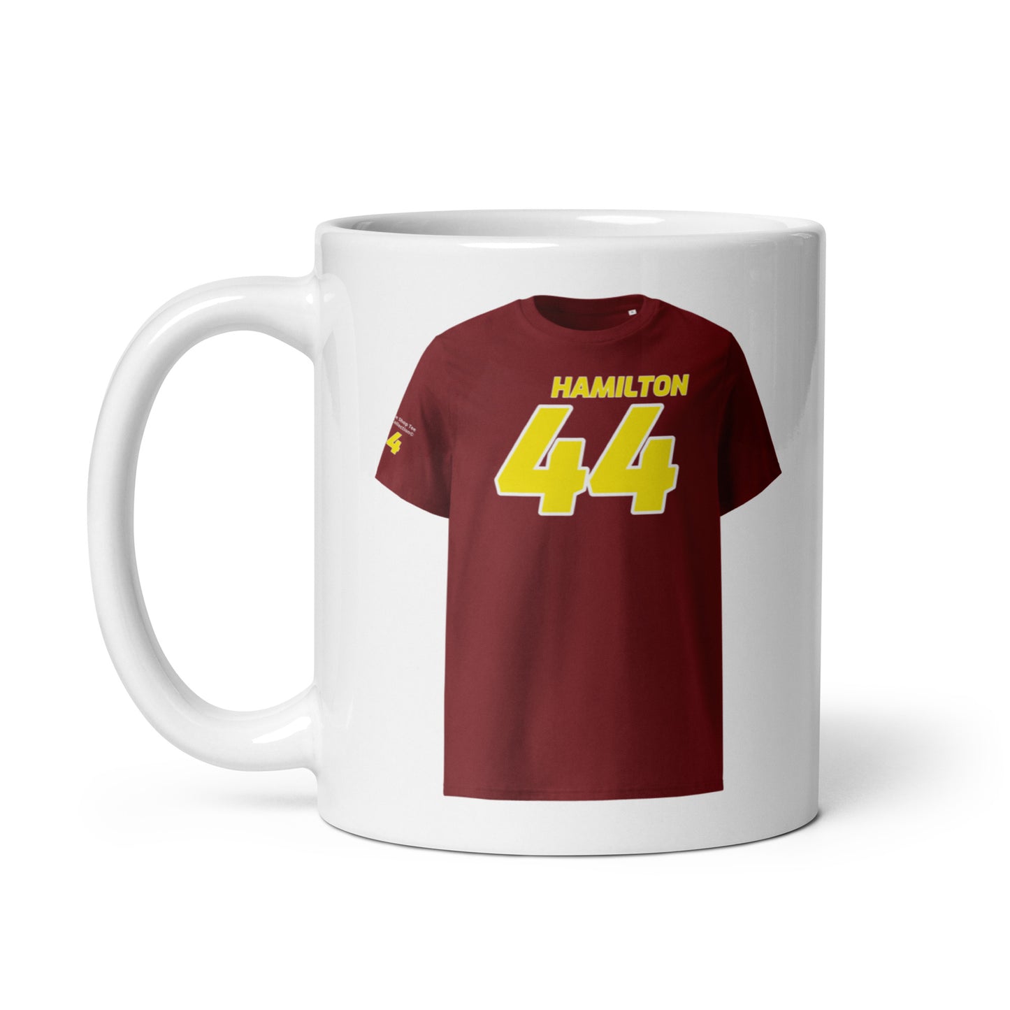 A white ceramic TeeMug© featuring a yellow design with "HAMILTON" in bold letters and the number "44". The mug is held by a handle on the left side.
