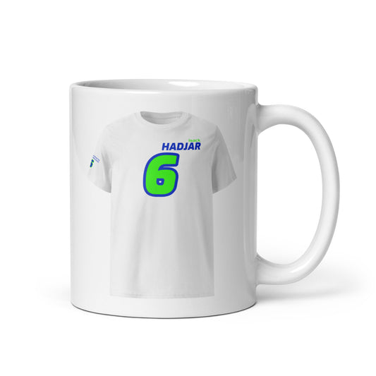 A white ceramic TeeMug© featuring a blue and green design with "HADJAR" in bold letters and the number "6". The mug is shown with the handle on the right side.