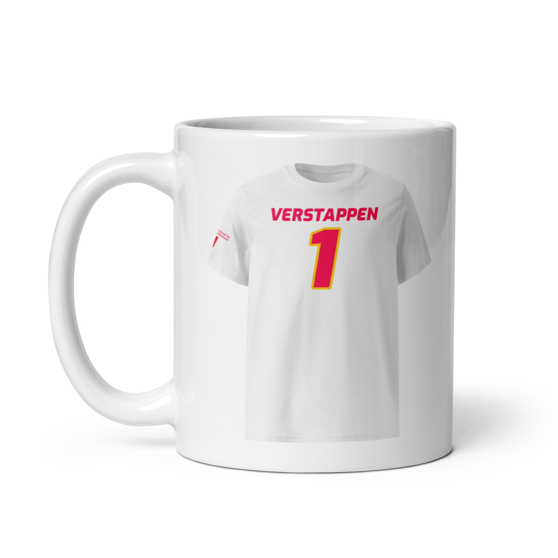 A white ceramic TeeMug© featuring a Red Bull pink design with "VERSTAPPEN" in bold letters and the number "1". The mug is held by a hand on the left side.