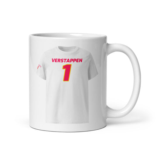 A white ceramic TeeMug© featuring a Red Bull pink design with "VERSTAPPEN" in bold letters and the number "1". The mug is held by a hand on the right side.

