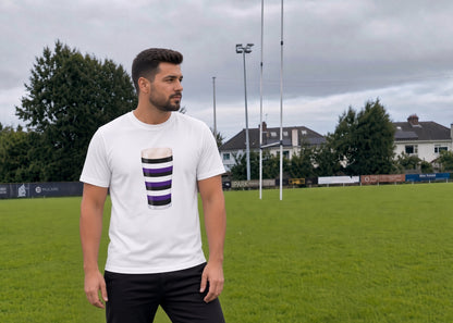 Male model wearing a white Terenure Mega Pint rugby t-shirt with a purple, black and white striped pint glass graphic, standing on a rugby pitch in Leinster