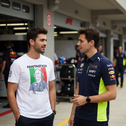 Two male motorsport fans in the paddock, one wearing a white FANTASTICO! GP race engineer T‑shirt and the other in a dark blue and neon yellow polo inspired by Red Bull colours, chatting near the garages.