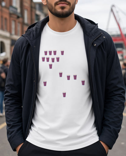Close-up of a white vintage Blackheath Team Pints rugby t-shirt showing scattered red and light blue striped pint graphics, styled with a jacket on a London street for match day supporters