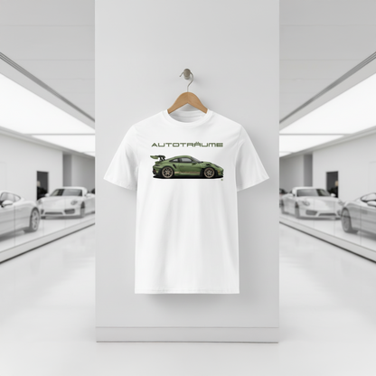 White AUTOTRÄUME GT3 T‑shirt with an olive green Porsche‑style car illustration hanging on a wooden hanger in a bright white sports car museum, with glossy floor reflections and blurred white and silver sports cars in the background.