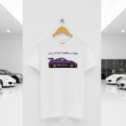 White AUTOTRÄUME T‑shirt with a purple Porsche‑style GT3 car illustration hanging on a premium wooden hanger and silver peg against a central white wall in a bright sports car gallery, with a glossy white floor and blurred white and silver sports cars running down both sides.