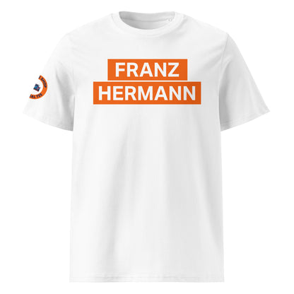 White organic cotton unisex t-shirt with bold orange "FRANZ HERMANN" block text on chest, inspired by Max Verstappen’s Nürburgring GT3 meme, front view. TheTeeShop F1 motorsport fan apparel.