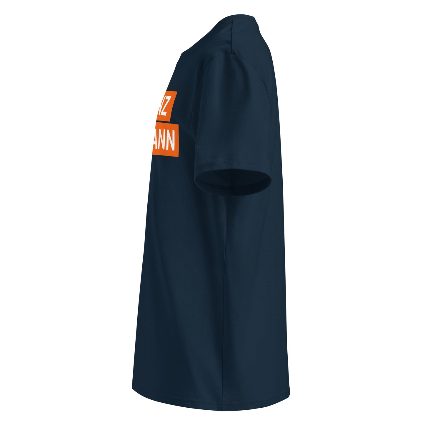 Left angle of navy "FRANZ HERMANN" meme t-shirt, orange block lettering and round sleeve logo visible. Designed for F1 and GT3 enthusiasts from TheTeeShop.
