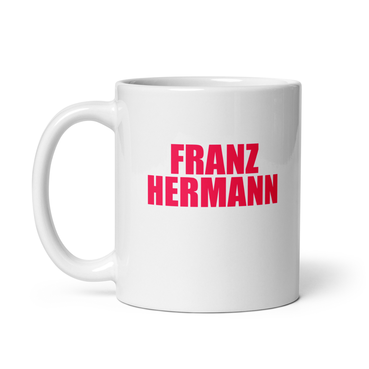 White mug with red bull pink text 'FRANZ HERMANN' on a white background. Handle on left.